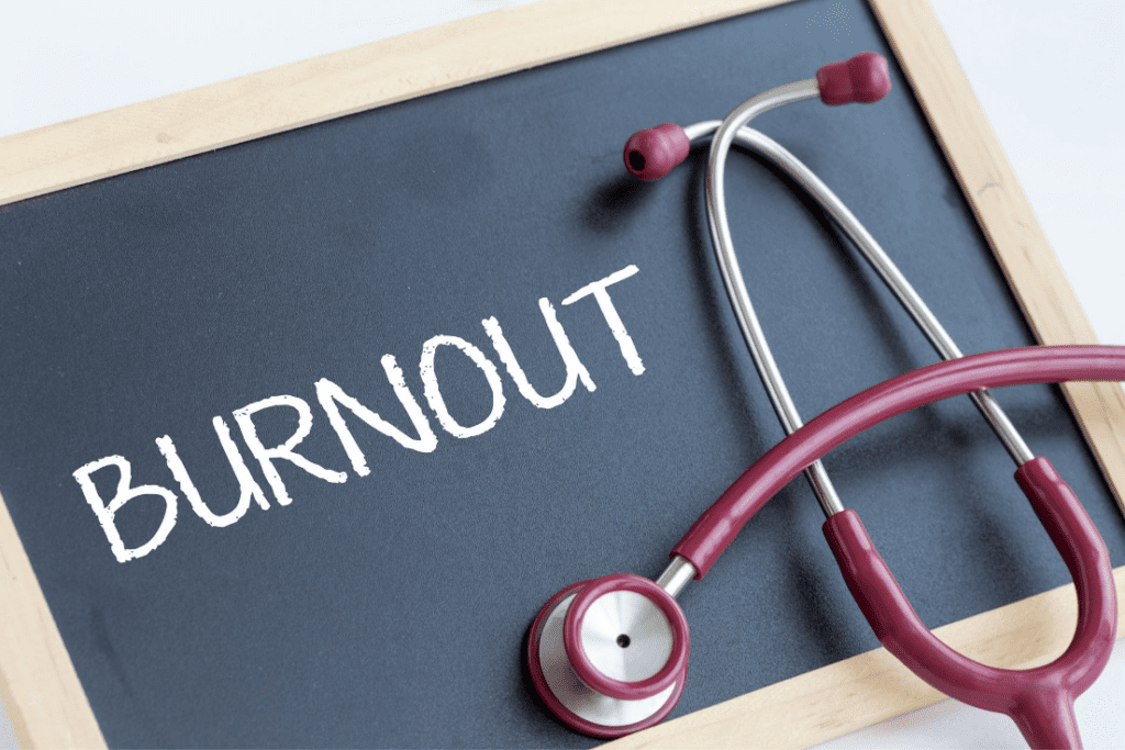 A chalkboard with the word "BURNOUT" written on it, accompanied by a stethoscope, symbolizing healthcare burnout.