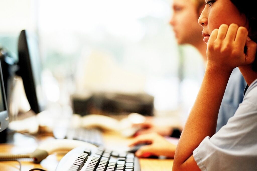 Close-up of a person working at a computer, focusing intently on a task, symbolizing concentration and effective implementation.