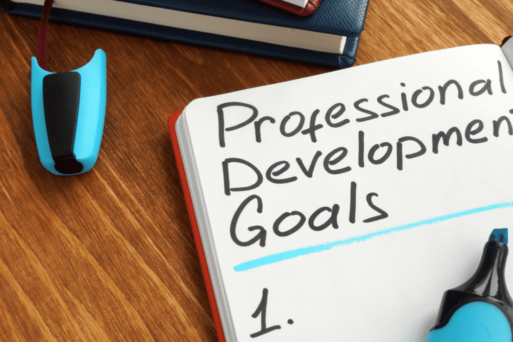 A notebook with the heading "Professional Development Goals" written on it, accompanied by a blue highlighter, representing the process of setting professional development goals.