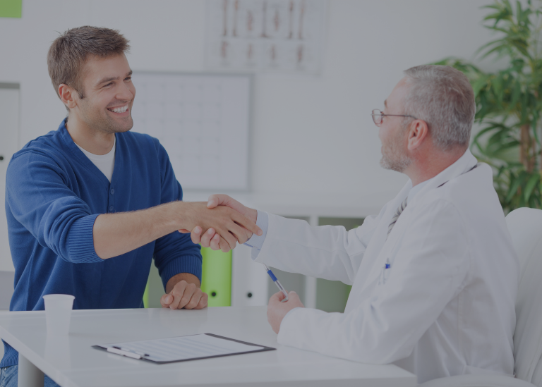 A healthcare professional shaking hands with a patient, symbolizing a successful provider enrollment and the importance of maintaining accurate records throughout the process.
