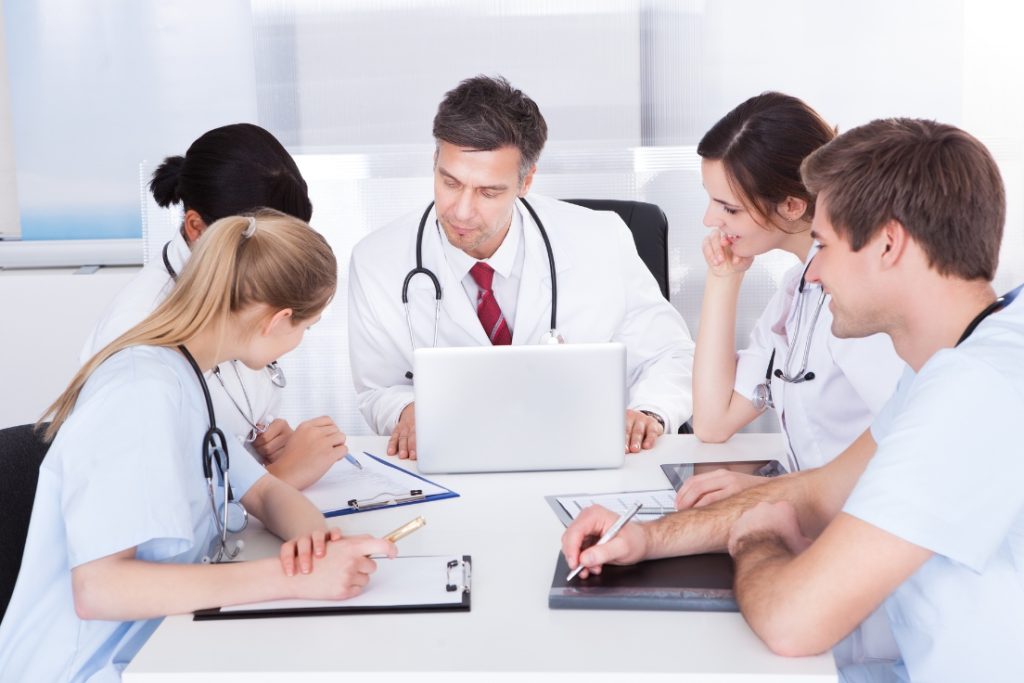 Healthcare professionals collaborate on a review, ensuring quality patient care and ongoing performance evaluations.