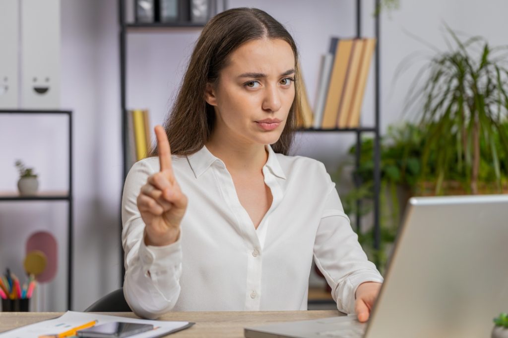 Picture of a woman putting her finger up in the air and pursing her lips.
